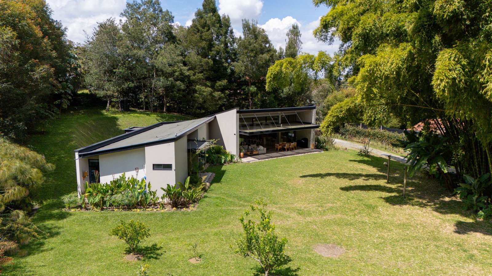 Vista aérea de casa campestre con jardín y bosque